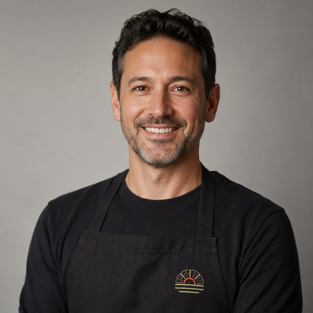 George Passantino, Co-Founder and CEO, professional headshot wearing an apron with the sunburst logo